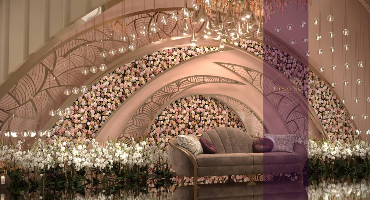 Ivory floral arch backdrop with fairy lights and a cream tufted sofa by RAW Group